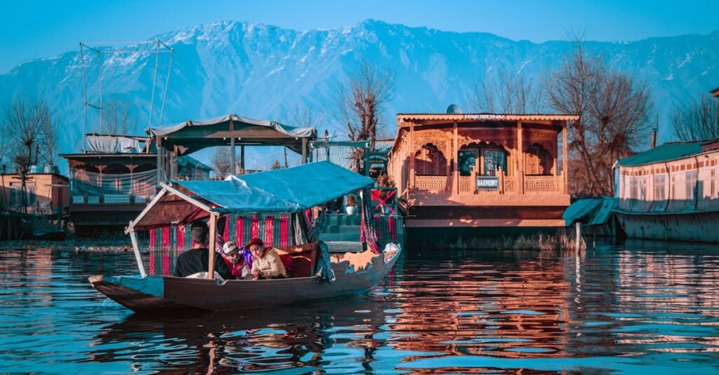 A group enjoying a serene Shikara ride on Dal Lake, with stunning mountain views in Srinagar, Kashmir.