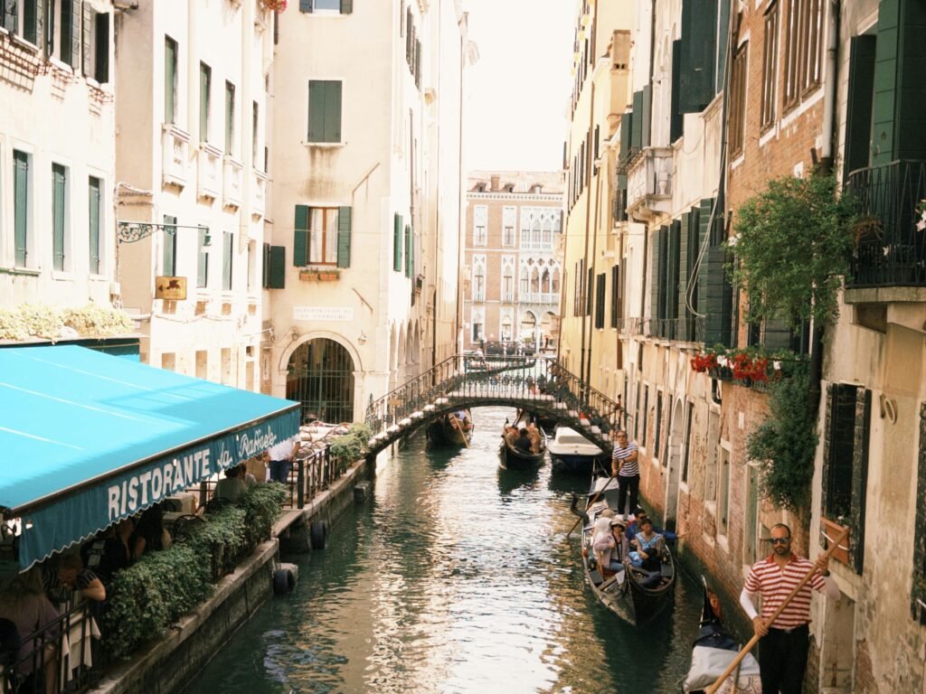 Scenic view of a Venetian canal with gondolas and historic architecture, capturing the essence of Venice.